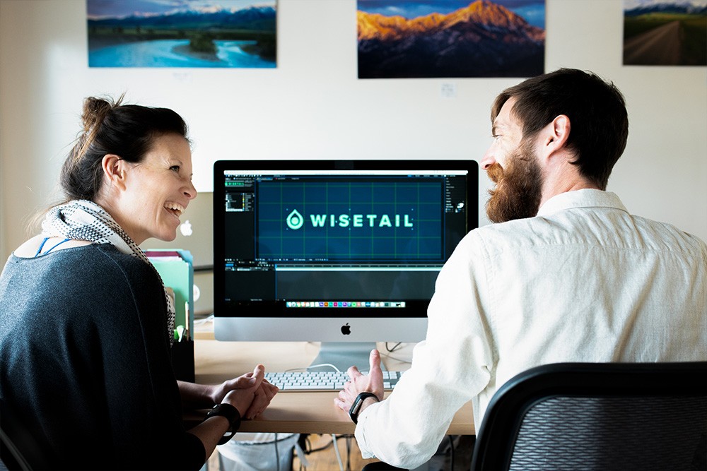 Wisetail LMS employees, Jill and Nick, share a laugh during a working session on a video project.