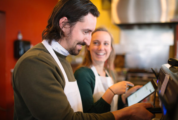 Restaurant employees train at the espresso machine while using their LMS.