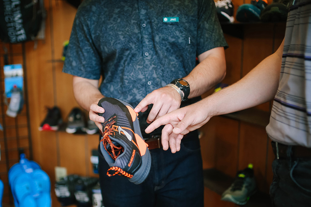 Two men pointing at new shoe in hand