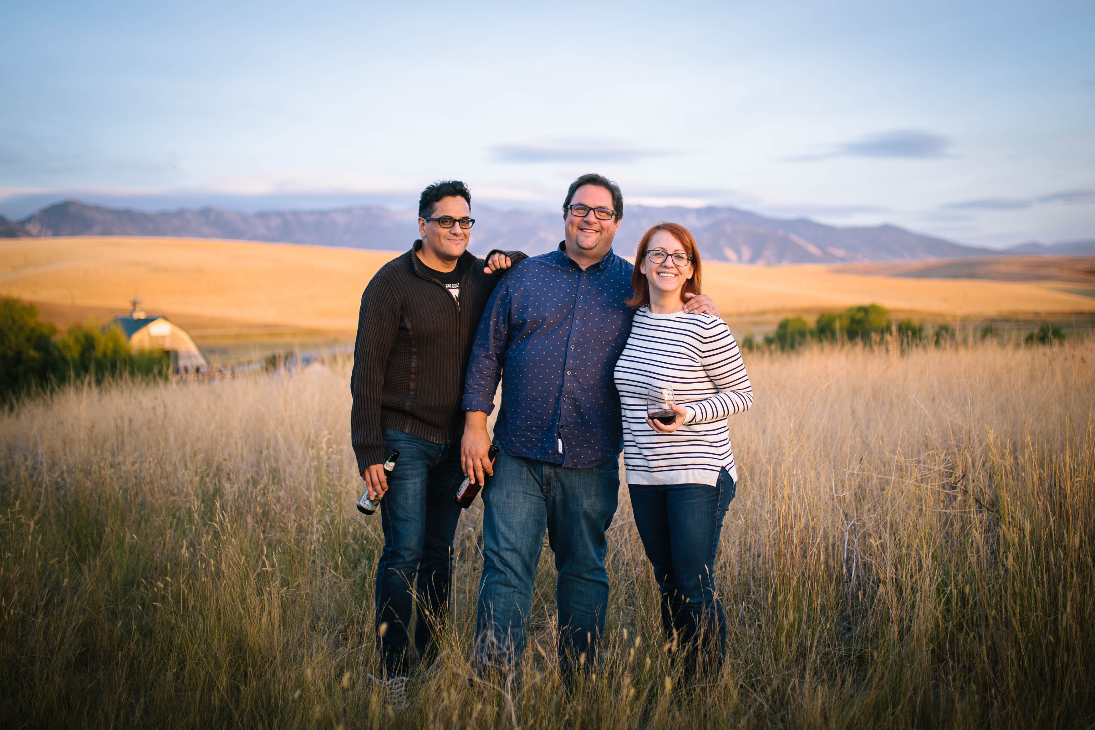 group of three in field with mountains in background