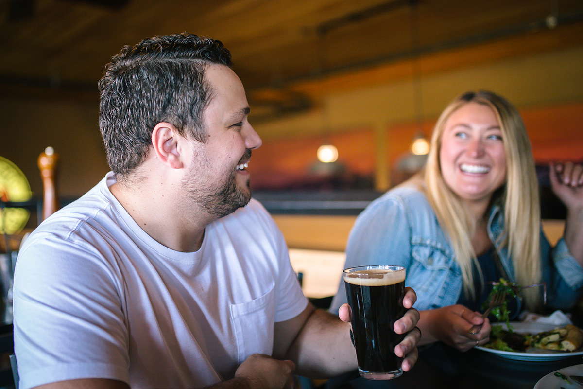 Two people dining at a restaurant share a laugh over dinner.