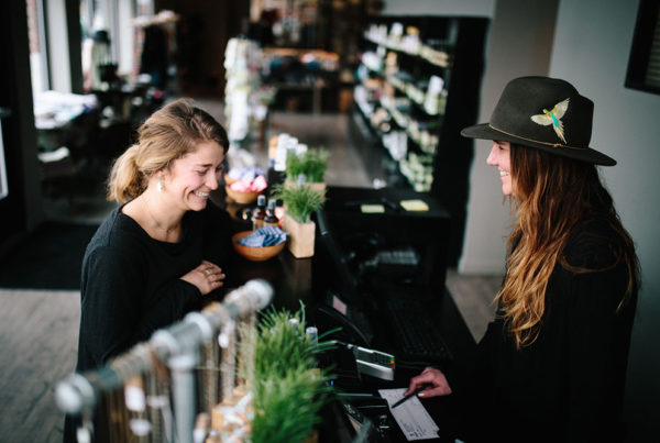 A retail employee and a customer pictured at checkout.
