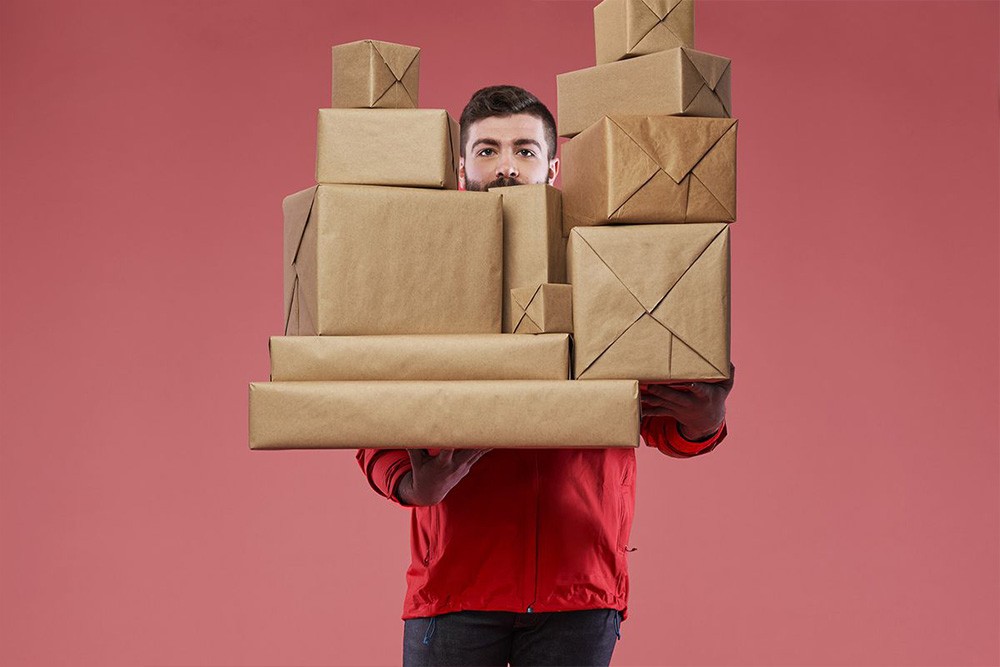 Wisetail LMS client, Hello Alfred, shows a man doing delivery and carrying boxes.