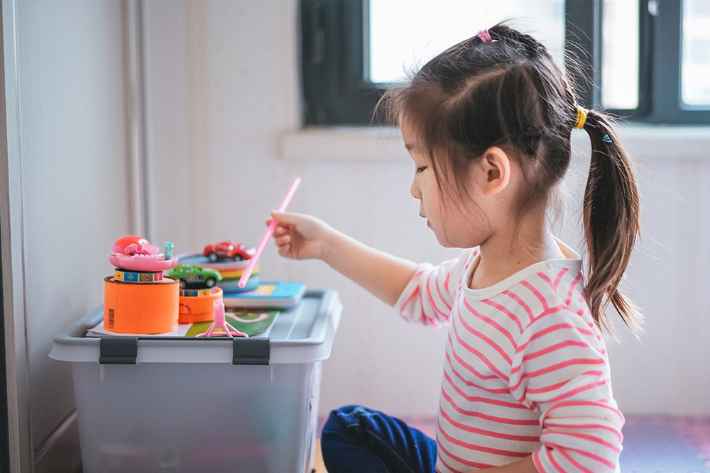 A young girl plays at home with toys.