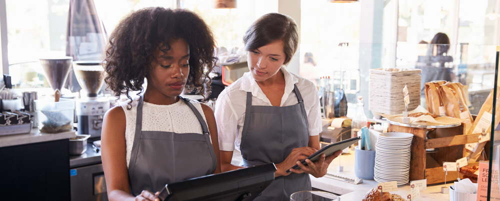 Photo: a new employee receiving training at delicatessen checkout