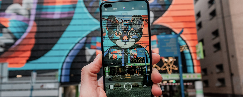 Photo: Photo of a smartphone taking a photo of mural art.