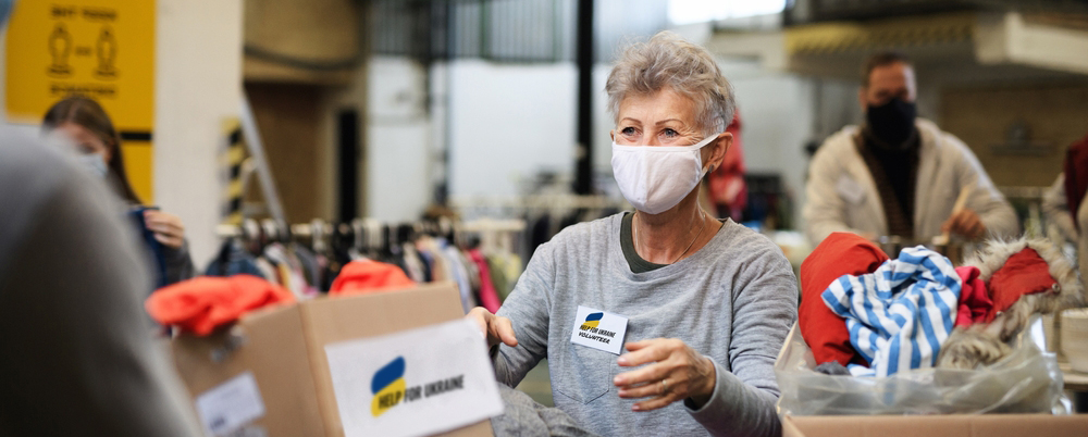 Volunteers collecting donations for the needs of Ukrainian migrants, humanitarian aid concept.