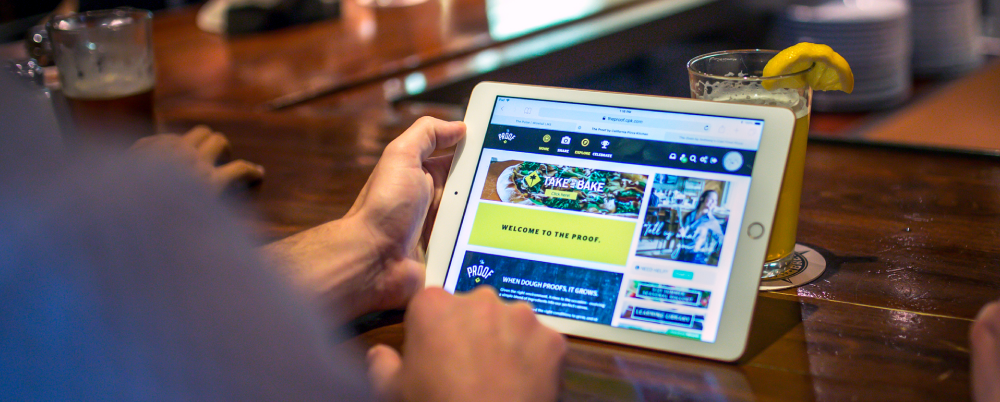 restaurant worker using ipad and wisetail lms in restaurant