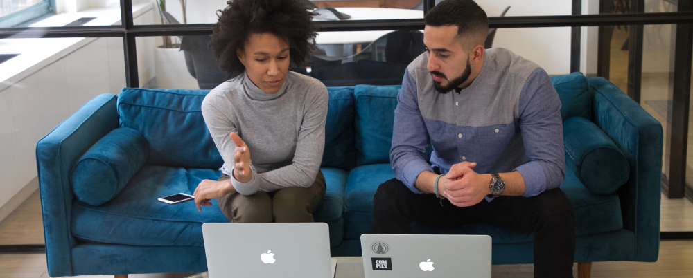 Two employees discussing elements of change on laptops