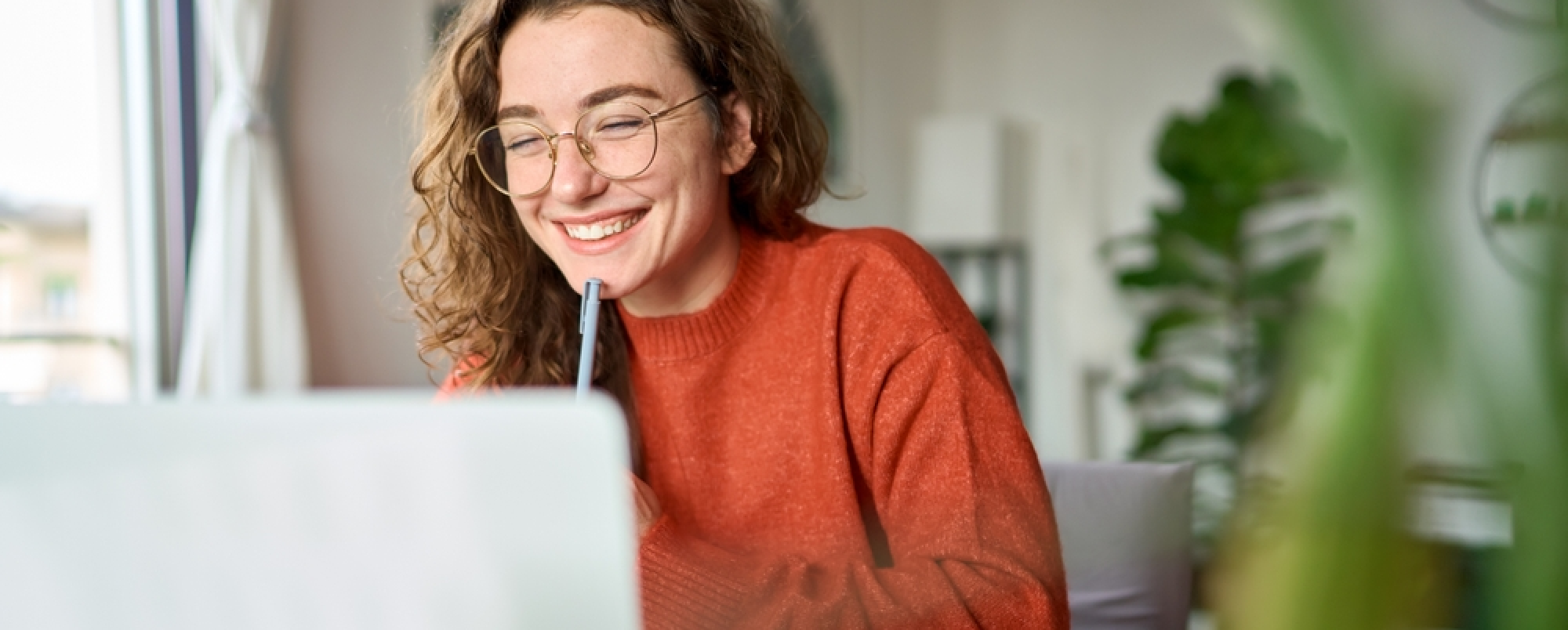 Employee planning 2023 at her laptop, smiling and excited for the future of L&D!