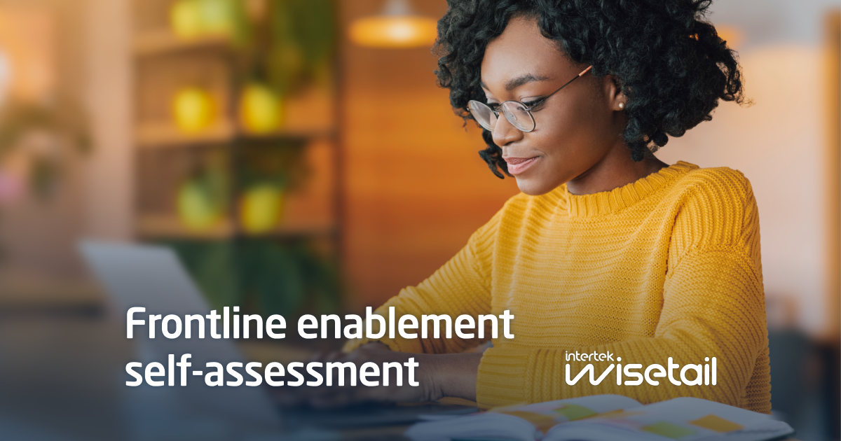 A woman in a yellow sweater and glasses works at a laptop in a warmly lit, cozy space. Text overlay reads "Frontline enablement self-assessment, Intertek wisetail."
