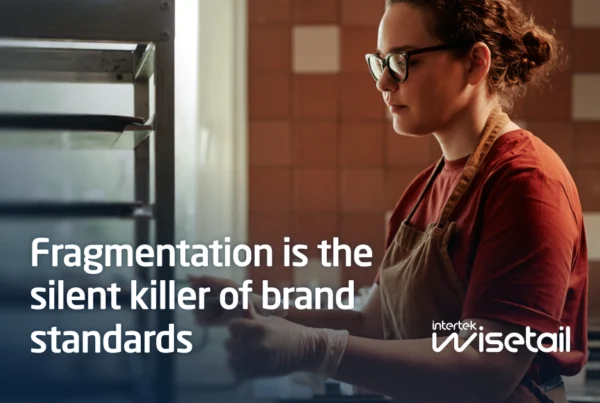 A woman in glasses and an apron works in a warm-toned kitchen. Text reads, "Fragmentation is the silent killer of brand standards." Mood is focused and contemplative.