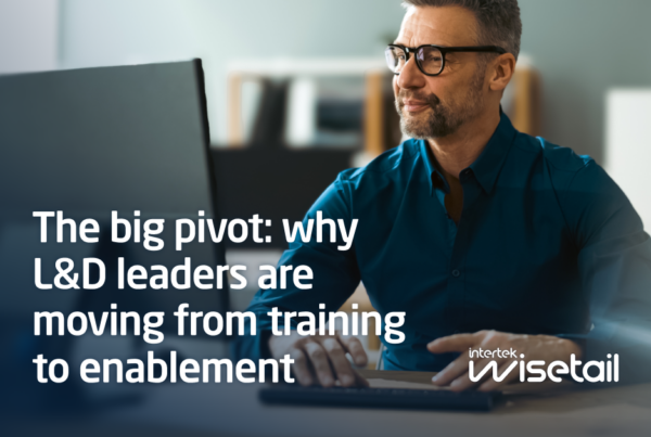 A man in glasses and a blue shirt sits at a desk with a focused expression. Text reads, "The big pivot: why L&D leaders are moving from training to enablement." Wisetail logo in the corner.