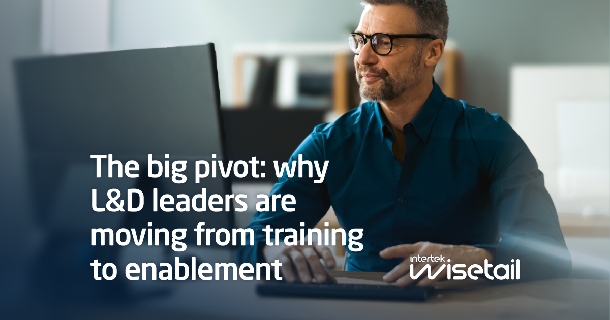 A man in glasses and a blue shirt sits at a desk with a focused expression. Text reads, "The big pivot: why L&D leaders are moving from training to enablement." Wisetail logo in the corner.
