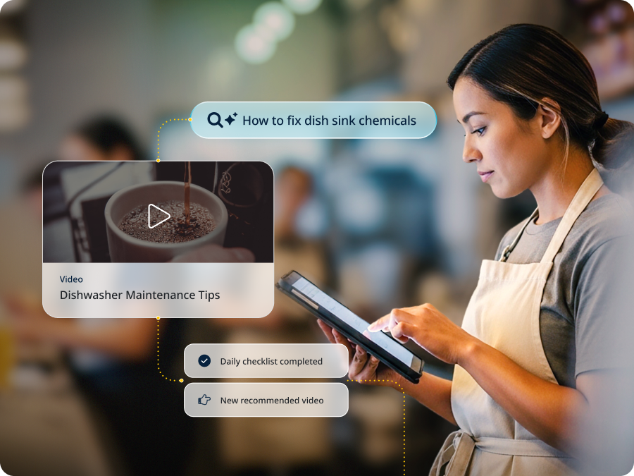 Restaurant worker reviewing a tablet with Wisetail AI search results for "How to fix dish sink chemicals," surfacing a Dishwasher Maintenance Tips video and daily checklist notifications.